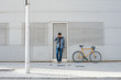 © Miquel Llonch/Stocksy - Man talking with a fixie bike talking with his phone on the street