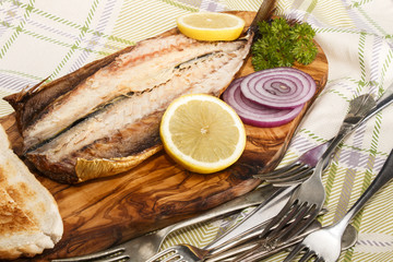 Poster - smoked mackerel on a wooden board with lemon, onion and toast bread