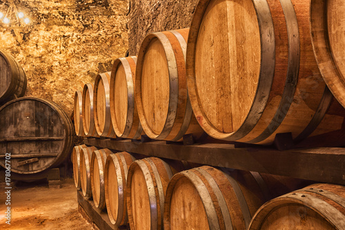 Photo Wooden barrels with wine in a wine vault