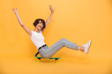 Portrait Of A Happy Cheerful Girl Sitting On A Skateboard