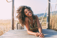 Beautiful Young Black Woman Lying Down In A  Wooden Foot Bridge At The Beach .