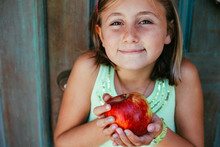Young And Cute Freckle Faced Girl Holding A Big, Red Apple