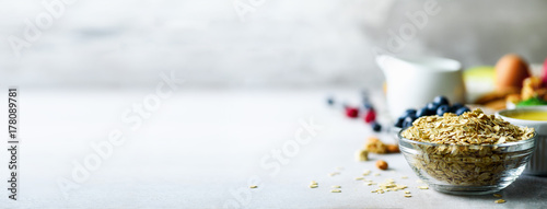 Cuadros en Lienzo Organic ingredients for healthy breakfast - berries, milk, egg, oatmeal on grey concrete background