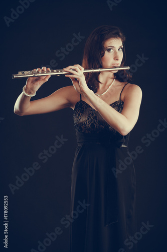 Zdjęcie XXL Kobieta bawić się poprzecznego flet na czerni.