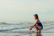 © Cindy Prins/Stocksy - Little girl sitting at the shoreline splashing the waves