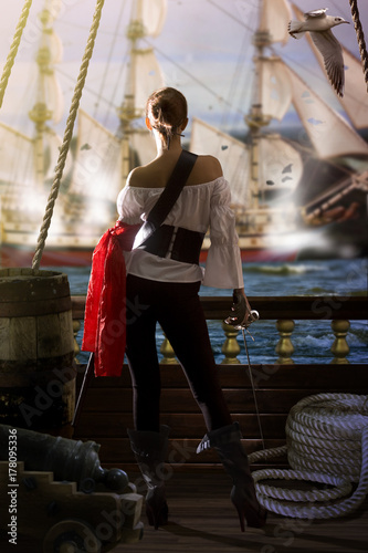 Cuadros en Lienzo pirate captain in sexy clothes calmly stands on the deck of her ship under enemy