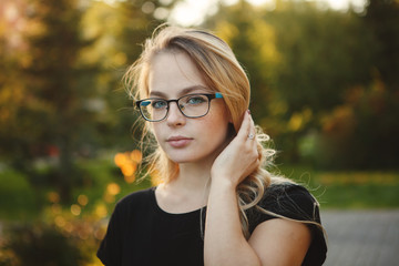 Beautiful woman in glasses on a autumn yellow background closeup portrait