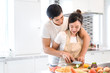 © Kiattisak - Couple cooking food in kitchen room, Young Asian man and woman together cutting slice vegetables making each salad for dinner menu with fruits at home romantic indoor sweet lover, copy space the left.