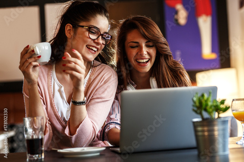 Zdjęcie XXL Dwa młodego żeńskiego przyjaciela siedzi przy kawiarnią i relaksuje na kawowej przerwie.