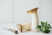 Food: Pleurotus Eryngii (king Oyster) Edible Mushroom With Parsley On White Wooden Background
