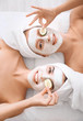 © Africa Studio - Young women with facial masks and cucumber slices in spa salon