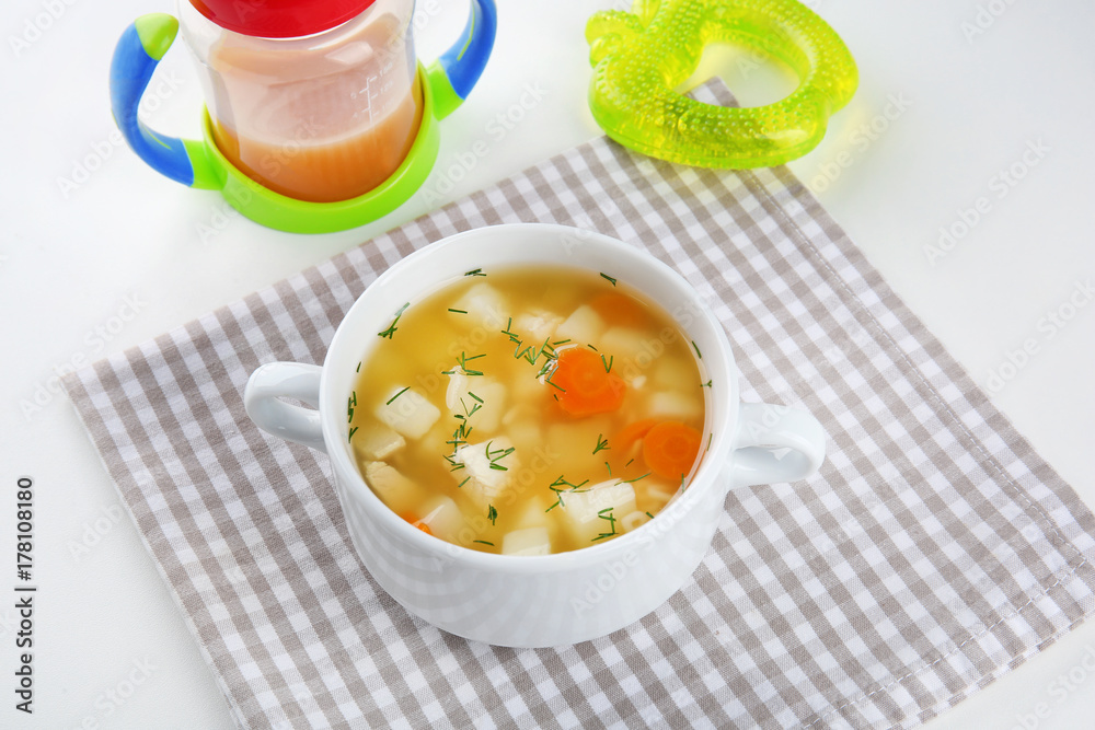 Bowl with delicious baby soup on table