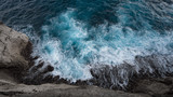 Fototapeta Natura - Aerial view to ocean waves and rock coast