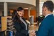 © bnenin - Cheerful car dealer handshake with customer in showroom.