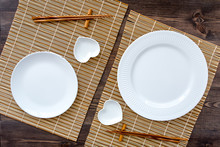 Table Setting For Sushi Roll. Empty Plate On Mat Near Chopstick And Bowl For Sause On Wooden Table Top View