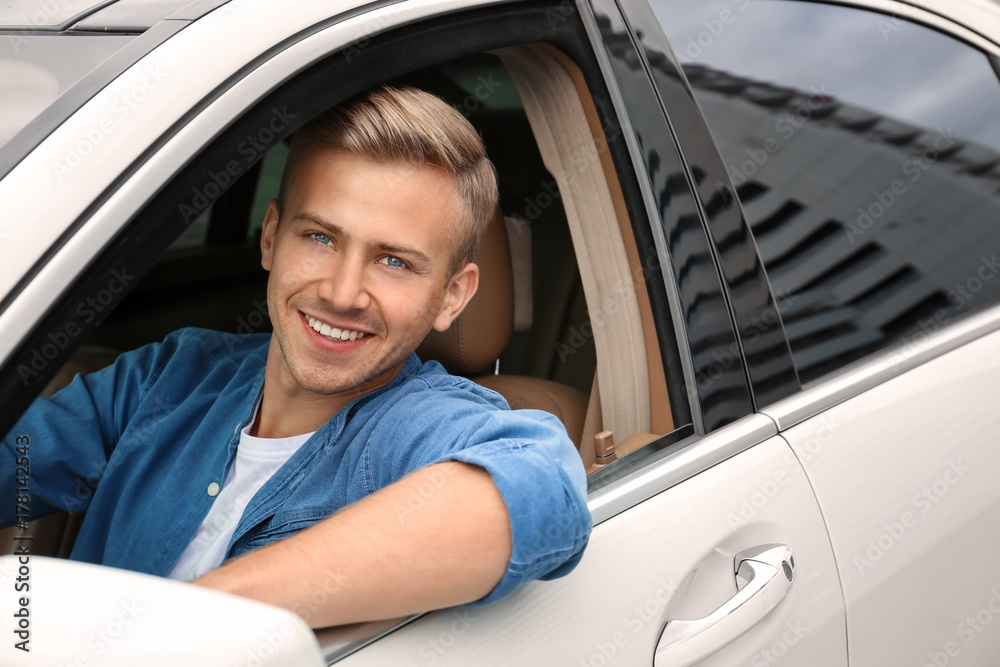 Young man on driver seat of car