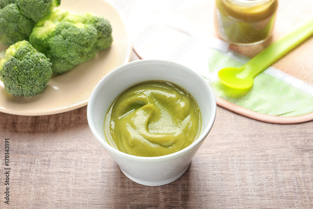 Ceramic bowl with baby food on table
