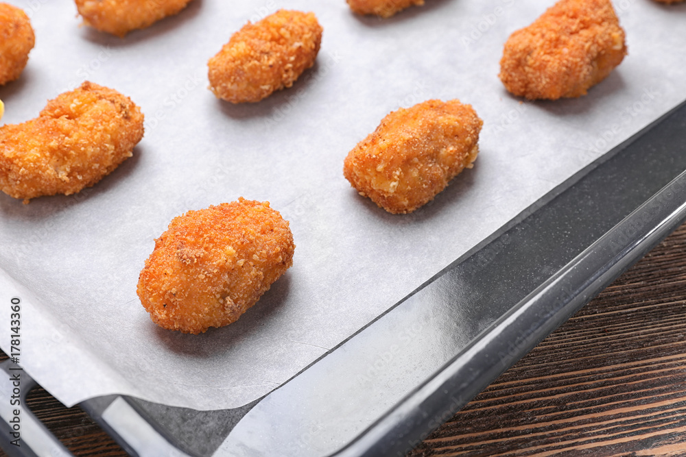 Delicious salmon croquettes in baking tray, closeup