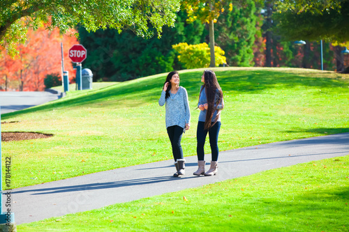 Zdjęcie XXL Dwie nastolatki rozmawiają podczas spaceru po parku jesienią