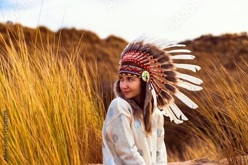 Beautiful young woman in black dotted white chief style Native American headdres Poster