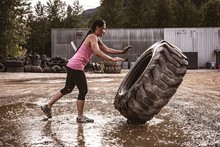Fit Woman Exercising With A Tractor Tyre