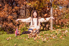 A Young Oriental Girl Is Throwing Autumn Leaves
