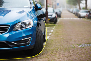 The car being charged on a street of a city