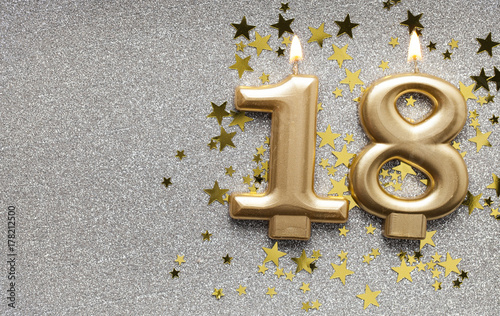 Photographie Number 18 gold celebration candle on star and glitter background