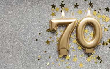 Wall Mural - Number 70 gold celebration candle on star and glitter background