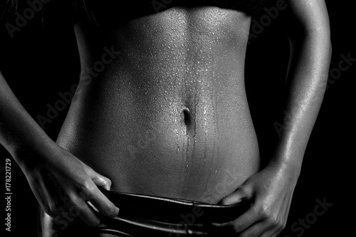 Zdjęcie XXL Fitness Model Lady kobieta spocony sportowy brzuch po ciężkich ćwiczeń, utrata masy ciała koncepcja czarno-biały