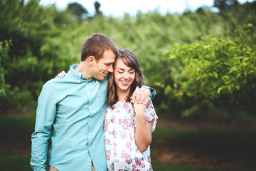 Loving couple embrace each other in orchard