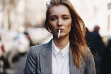 Blonde Girl With Cigar Stands On The Street