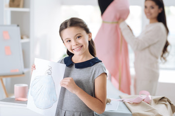 Happy smart girl showing her drawing