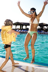 two happy children playing on the swimming pool at the day time. people having fun outdoors. concept