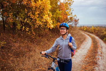 Wall Mural - Young woman riding a bicycle in the autumn field