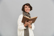 © Drobot Dean - Smiling young pretty woman wearing scarf reading book.