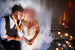 © IVASHstudio - Blurred picture of bride with pink hair and stylish groom sitting on footsteps with shiny candles