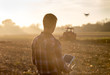 © Budimir Jevtic - Farmer navigating drone above farmland