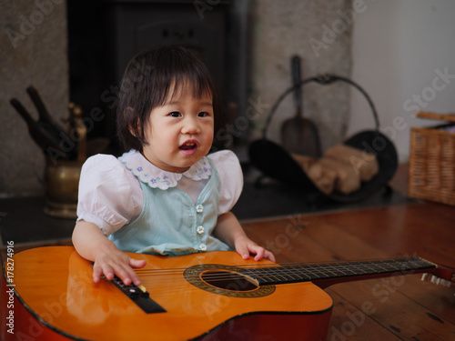 Plakat dziewczynka gra na gitarze w domu