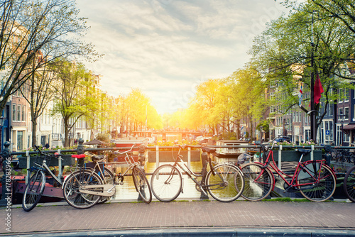 Plakat Bicykl na moscie z holandii tradycyjnymi domami i Amsterdam kanałem w Amsterdam, holandie.