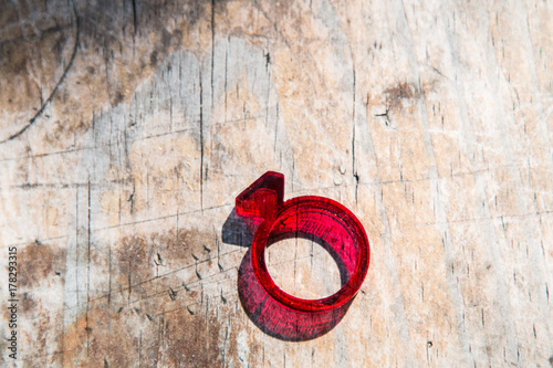 Fotografie, Obraz Modern red acrylic ring with diamond shape on distressed wooden table