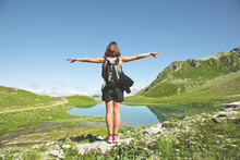 Hiker Woman Contempling A Beautiful Lake Landscape With Extended Arms. Alps, France.