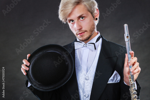 Plakat Elegancko ubrany muzyk trzyma flet