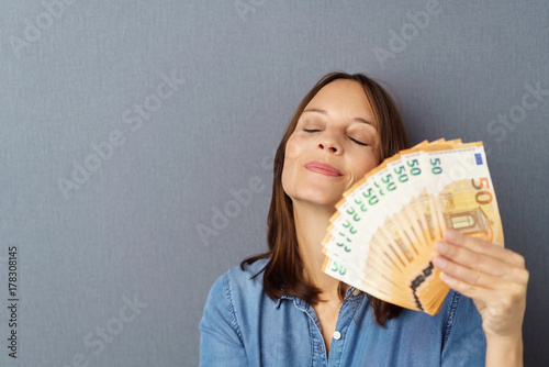 Frau Halt Einen Facher Mit Geld In Der Hand Und Schliesst Glucklich Die Augen Stock Photo Adobe Stock