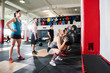 © Tyler Olson - Trainers Looking At Clients Throwing Medicine Balls On Wall