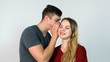 © Media Whale Stock - Man whispering a secret to a surprised young woman on white background. Bright picture of man and woman spreading gossip. Young guy whispers in ear the word girl and she laughs