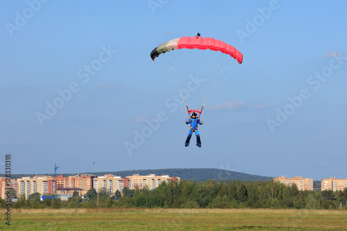 Plakat spadochroniarz wylądował na zielonym polu w letni dzień