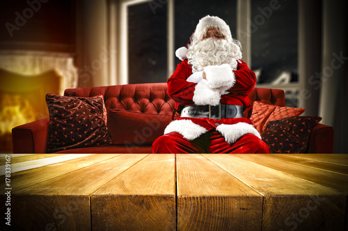 Plakat Święty Mikołaj na kanapie i drewnianym stole miejsce