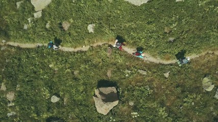 aerial shooting from flying drone hiking group walking on mountain trail