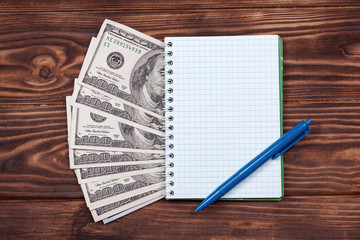 Aufkleber - Notebook with Ballpoint Pen and Dollar Banknotes on a Wooden Table